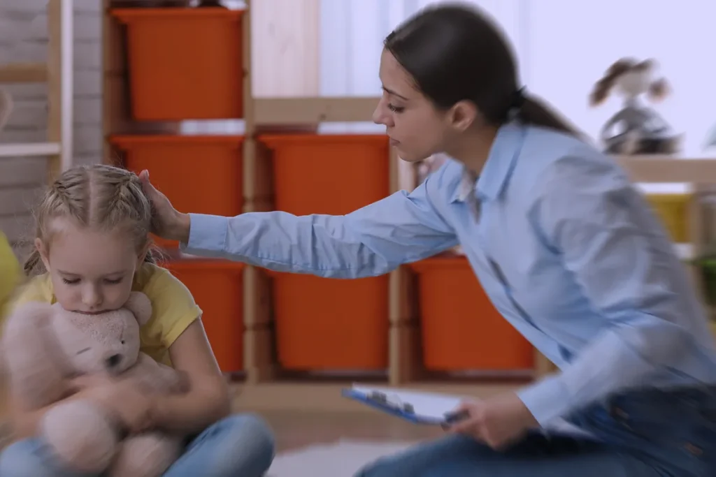 docente che consola una bambina a scuola