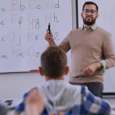docente davanti a una lavagna spiega in classe
