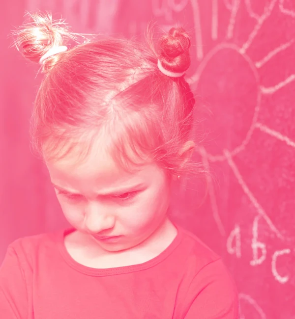 bambina triste davanti a una lavagna