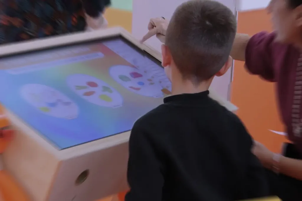 PINGUIN_2 Bambino utilizza il banco interattivo Pinguin per un esercizio su orologio e concetti di tempo